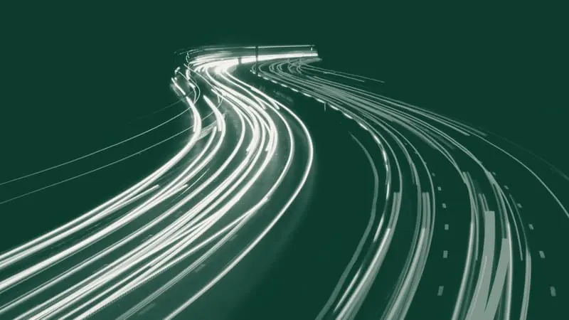 Light trails from traffic on a curving highway at night